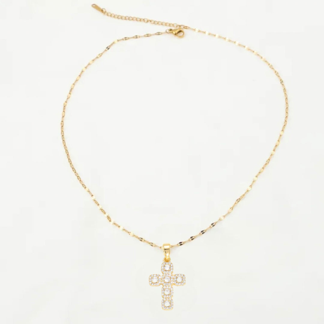 Gold necklace with a cross pendant on a white background