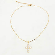 Gold necklace with a cross pendant on a white background
