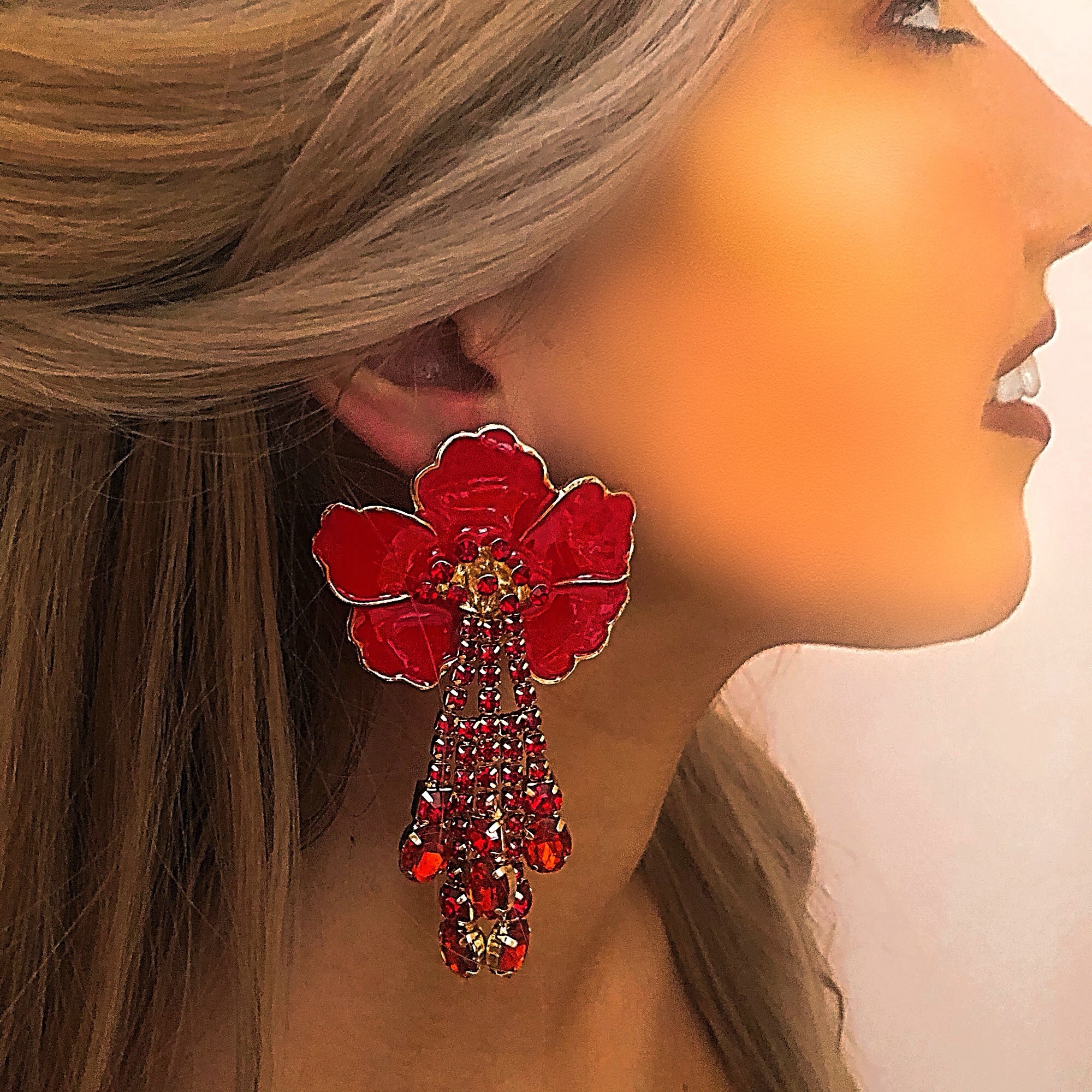 Large red statement flower earrings with gold details and dangling gems 