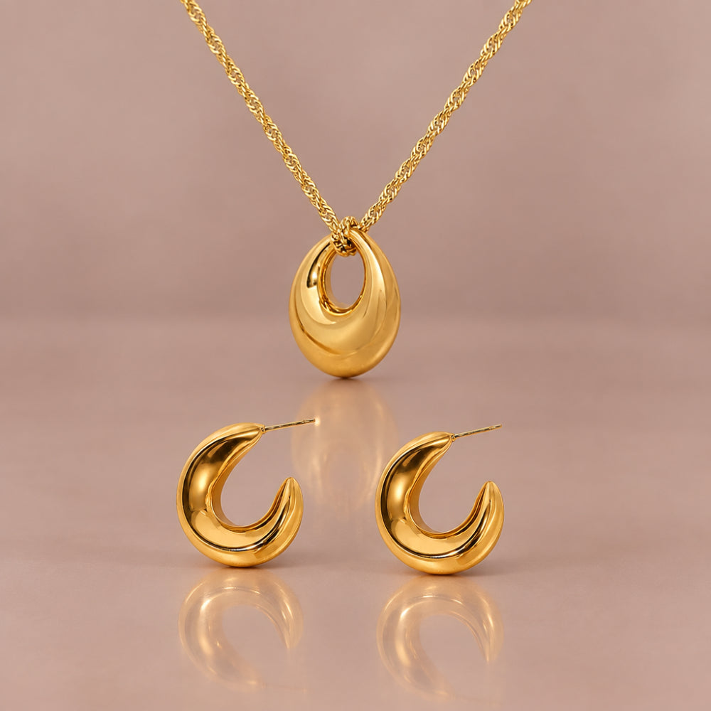 Gold twist chain necklace with hoop pendant beside curved gold hoop earrings.
