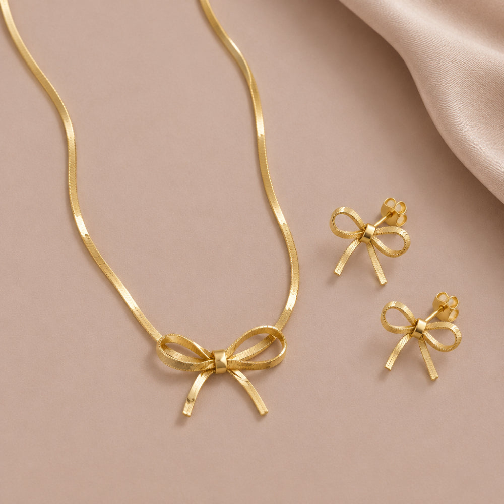 Gold bow necklace with slim snakeskin style chain and matching bow stud earrings