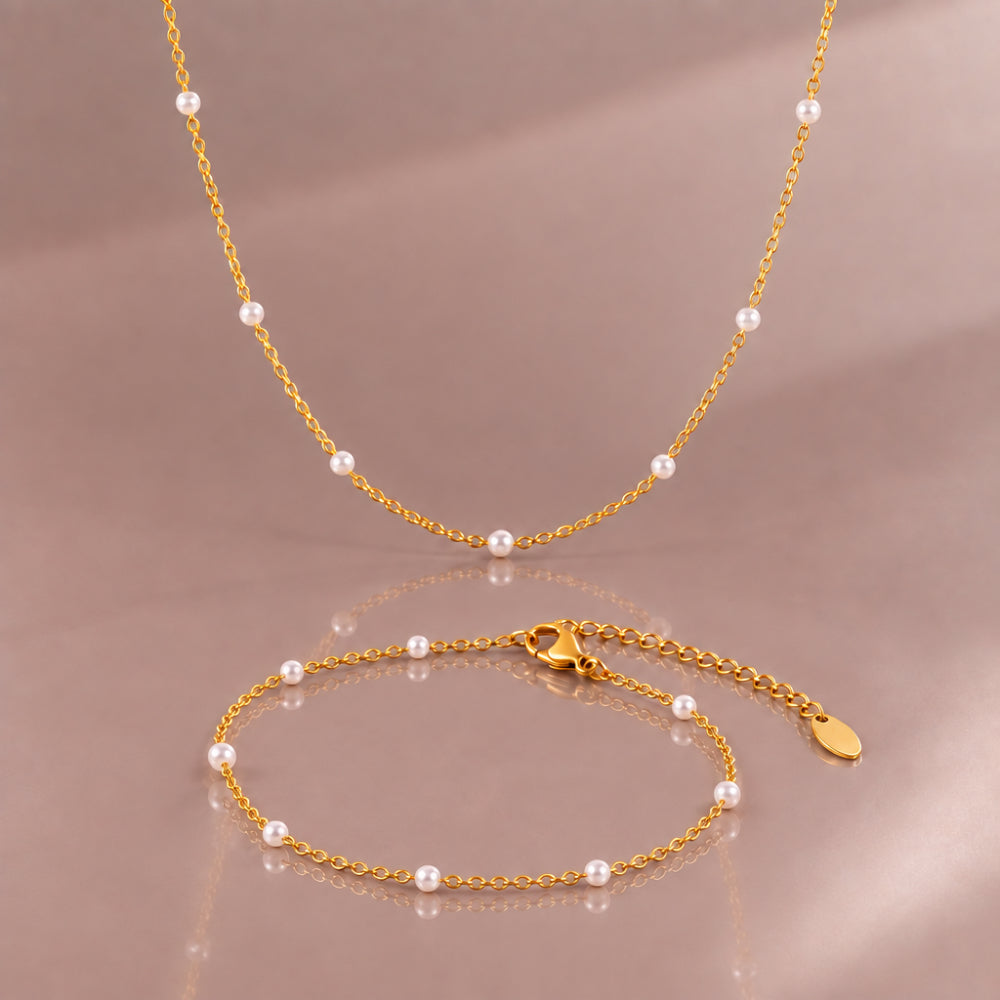 Delicate gold chain necklace and matching bracelet fitted with white pearl details