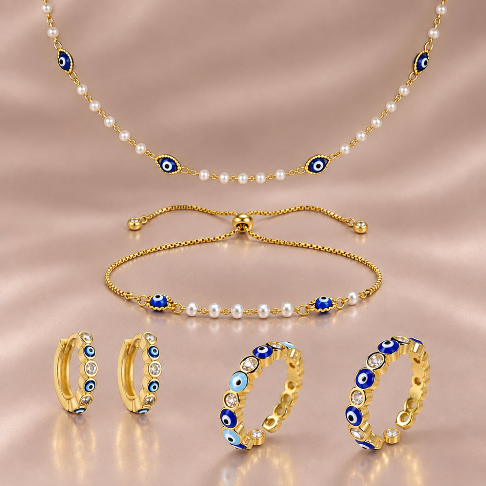 Gold plated royal blue evil eye necklace, pearl bracelet, sparkling huggie earrings and adjustable rings.