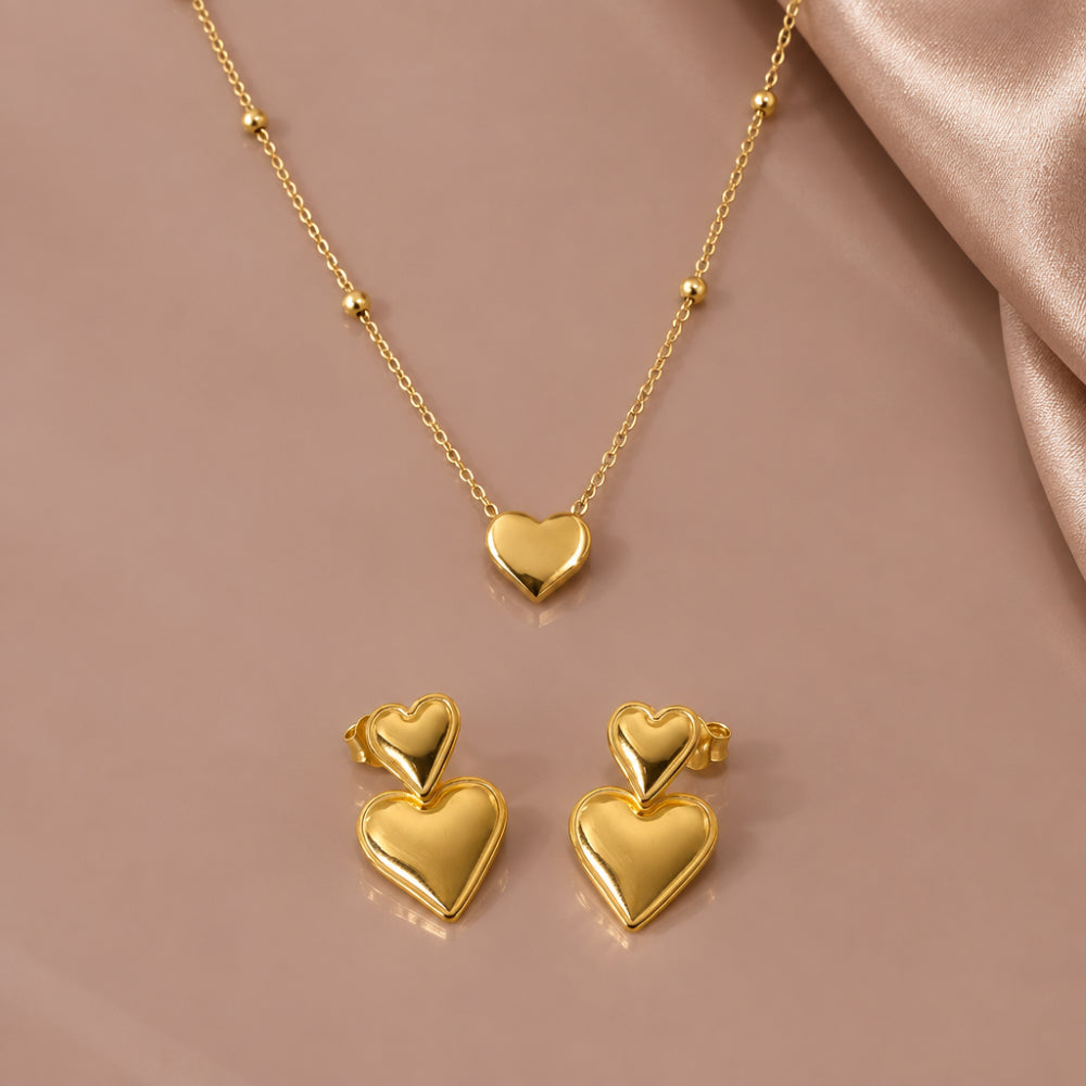 Gold heart pendant necklace with beaded chain and matching double heart drop earrings 