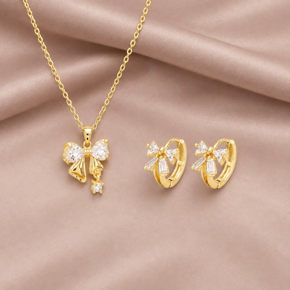 Gold plated bow pendant necklace and matching bow huggie earrings embellished with sparkling cubi c zirconia