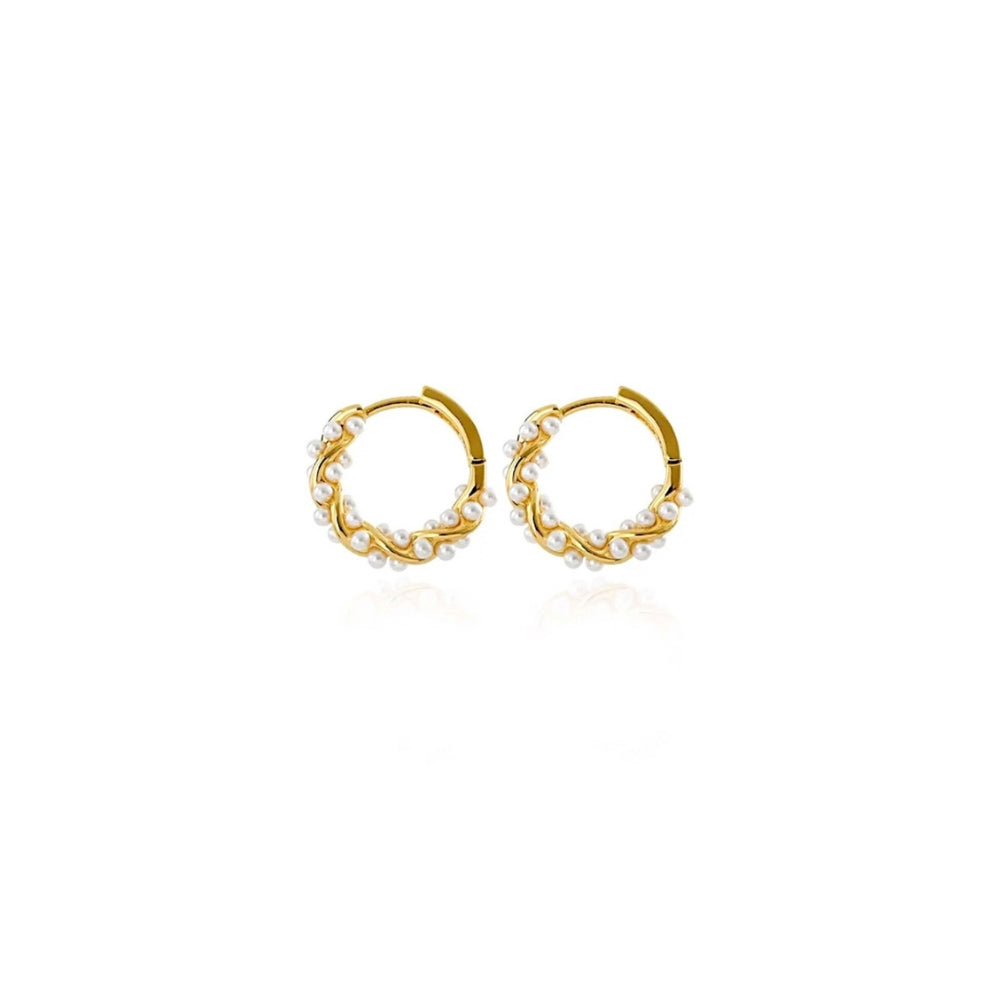 A pair of gold huggie hoop earrings decorated with small white pearls, shown on a clean white background with a subtle reflection.