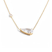 A delicate gold chain necklace featuring a large teardrop-shaped clear gemstone pendant in a gold bezel setting, with a smaller accent gemstone on the chain, shown against a solid white background.