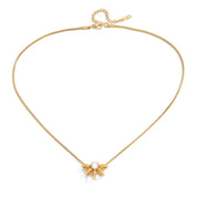 A delicate gold snake chain necklace with a small gold flower pendant featuring a clear central stone, displayed on a clean white background.
