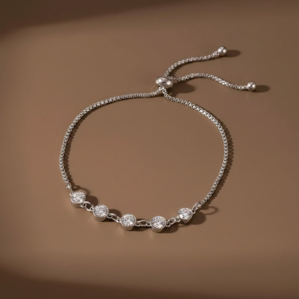 Five Stone Crystal Bezel Bracelet in silver on a warm beige background, showing the bracelet detail and adjustable bolo closure