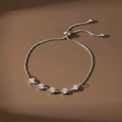 Five Stone Crystal Bezel Bracelet in silver on a warm beige background, showing the bracelet detail and adjustable bolo closure