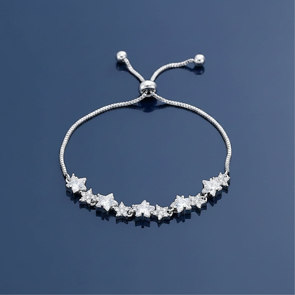 A silver adjustable slide bracelet featuring a row of star-shaped clear gemstones, displayed on a dark blue reflective surface.