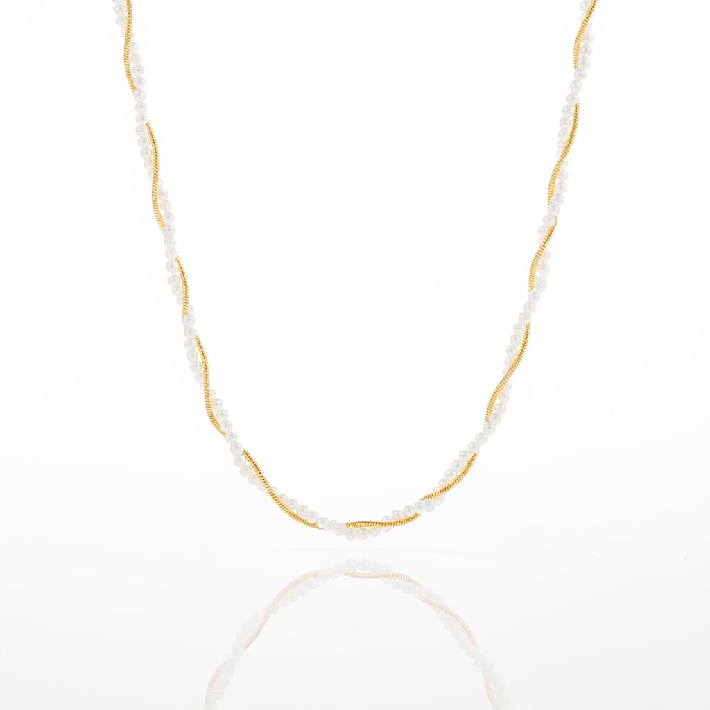 A delicate necklace featuring a twisted gold center with small white pearl-like beads draped along the sides, displayed on a clean white background with a soft reflection below.