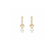 A pair of gold huggie hoop earrings with pavé-set clear stones and a dangling white pearl, shown on a plain white background.