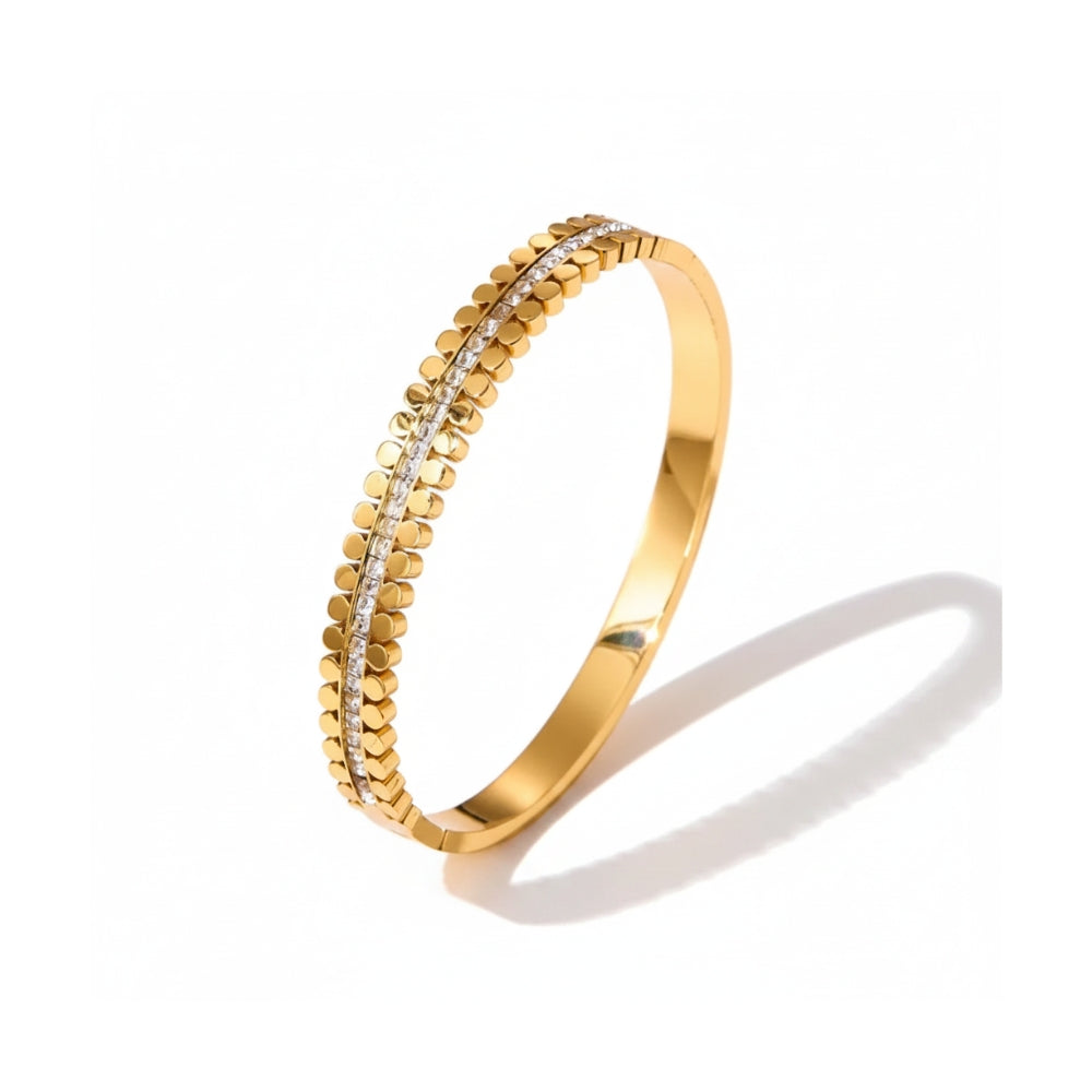 A gold bangle bracelet featuring a textured beaded outer edge and a central channel set with small clear stones, shown on a white background with a soft shadow.