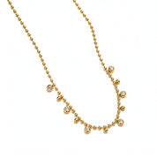 A gold ball-chain necklace featuring six small, bezel-set clear round gemstones spaced along the chain, displayed on a clean white background.