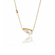 A gold chain necklace with a marquise-cut clear crystal pendant, displayed against a clean white background with a soft reflection below.