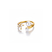 A gold open-band ring featuring two white pearls and a small cluster of clear marquise-cut stones, photographed on a clean white background.