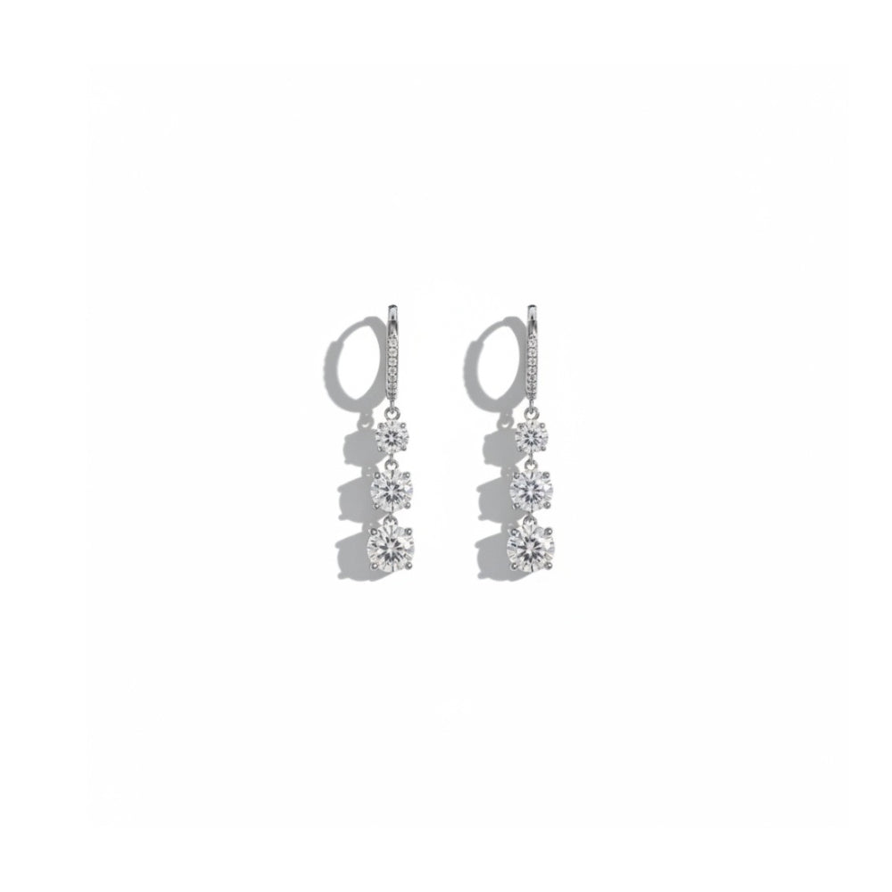 A pair of silver drop earrings with three clear gemstones in each earring, displayed against a solid white background.