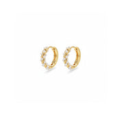 A pair of gold huggie hoop earrings decorated with small white pearls, shown on a clean white background.