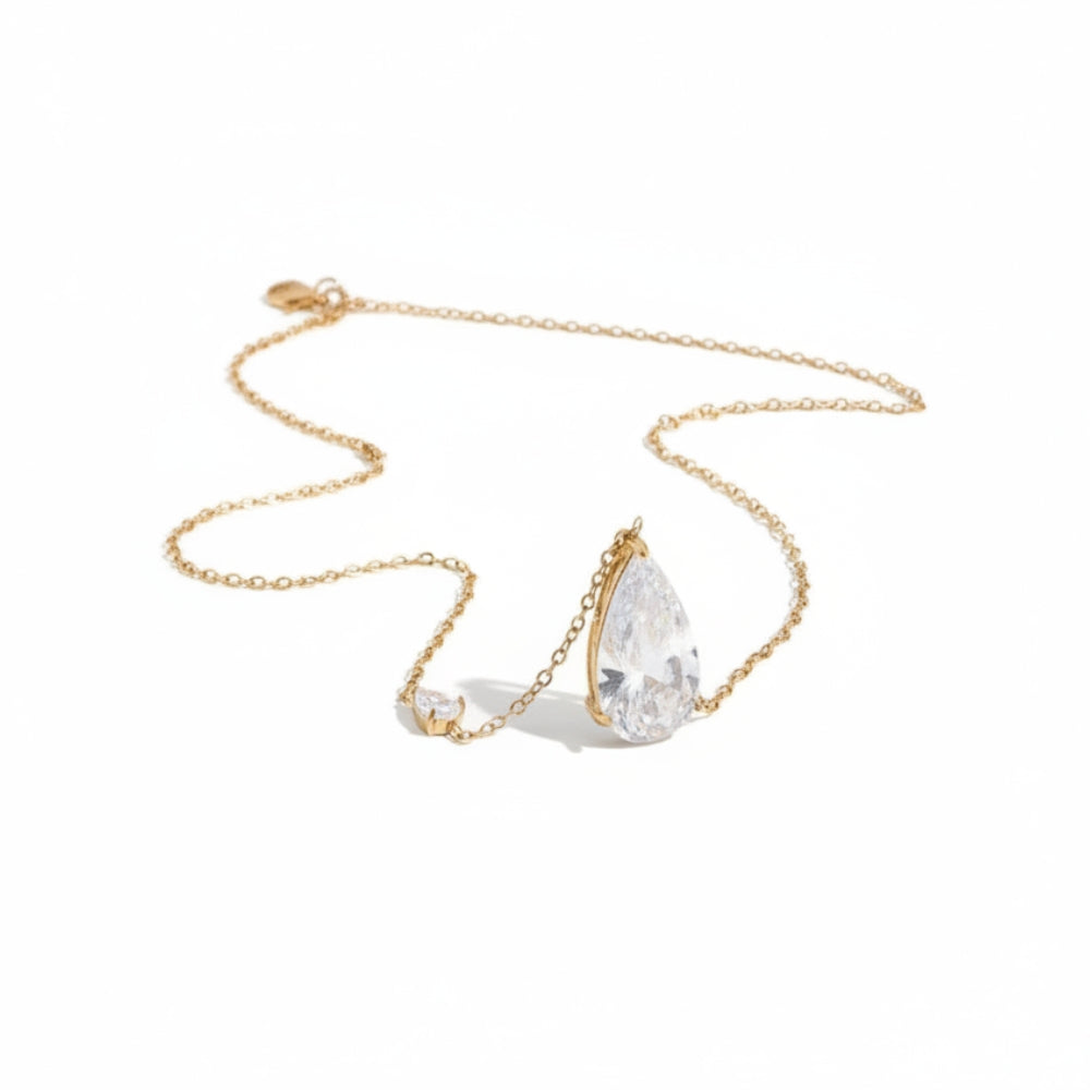 A gold chain necklace featuring a teardrop-shaped clear gemstone pendant and a smaller matching clear gemstone charm, displayed on a clean white background.