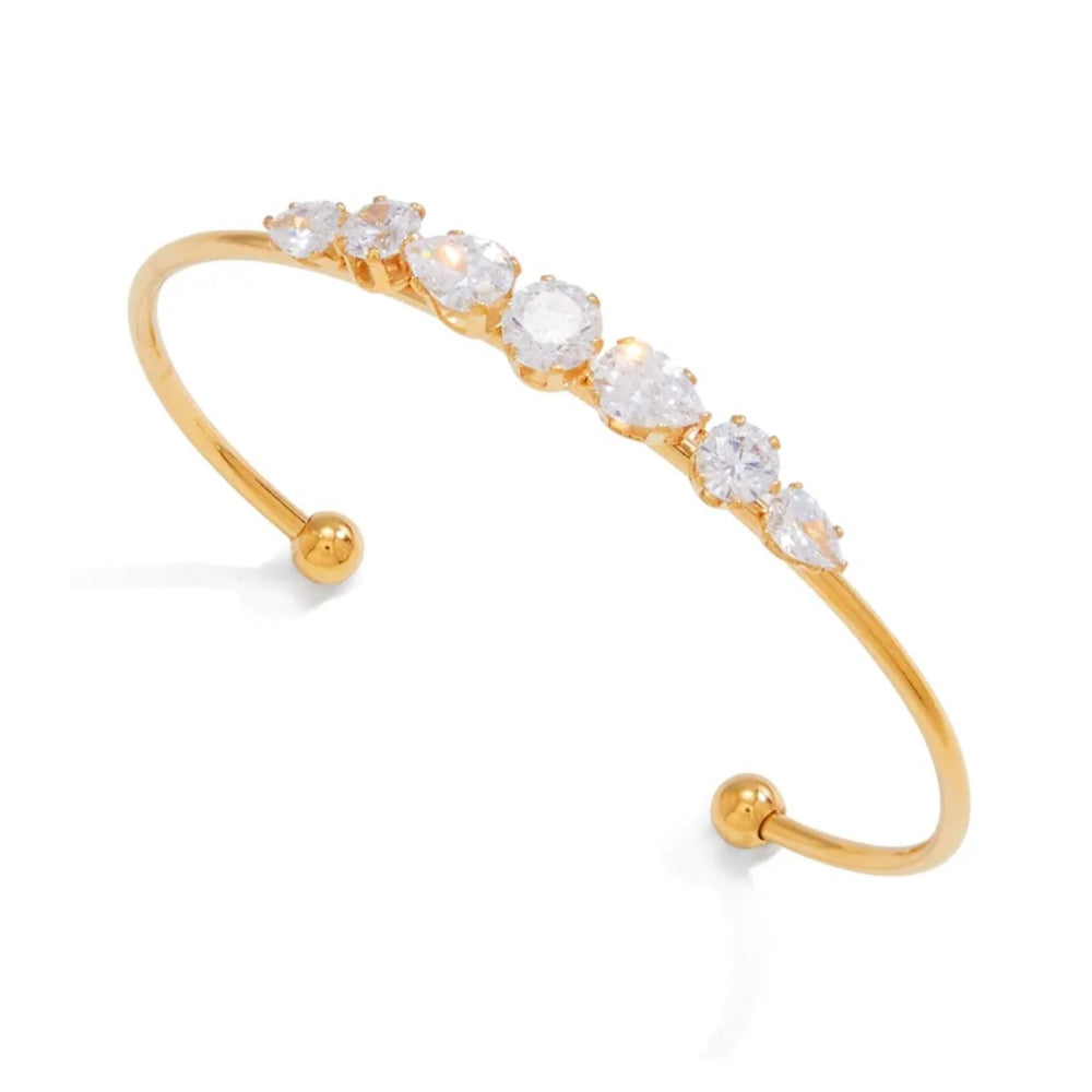 A gold open cuff bangle bracelet featuring a row of clear marquise-cut gemstones, displayed on a clean white background.