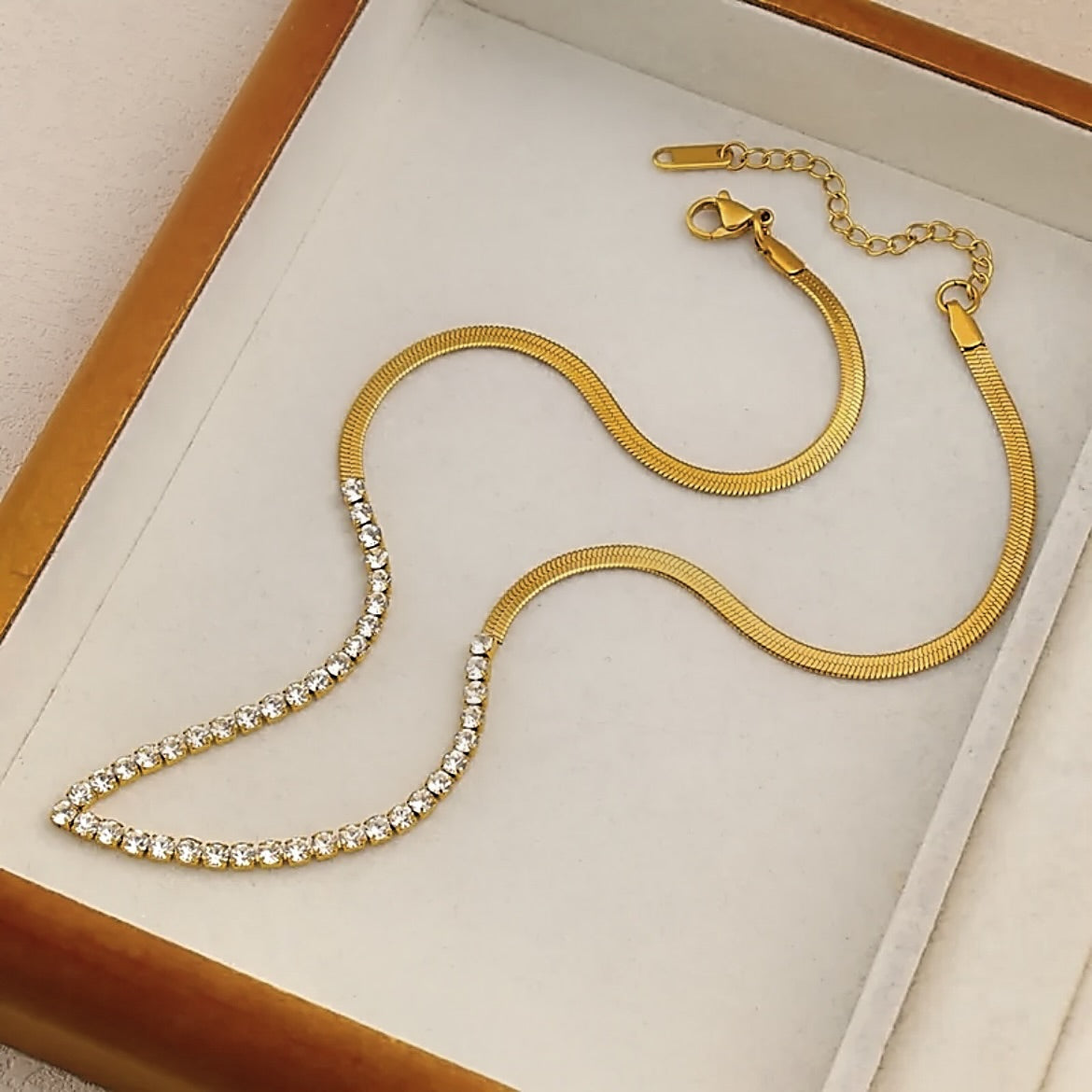 Gold necklace with diamond accents on a white surface