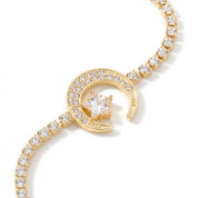A delicate gold-toned bracelet with a crescent moon and star motif, adorned with small clear stones, shown against a white background 