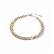 A gold-plated choker necklace adorned with clear rhinestones, arranged in a circular shape on a clean white background.