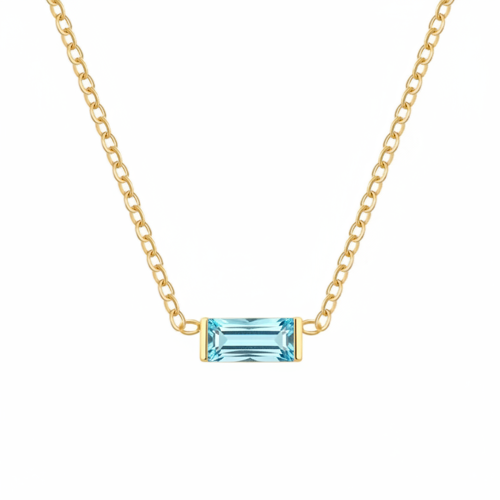 A delicate gold chain necklace featuring a small rectangular emerald-cut turquoise gemstone pendant in a gold bezel setting, shown against a plain white background.