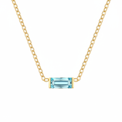 A delicate gold chain necklace featuring a small rectangular emerald-cut turquoise gemstone pendant in a gold bezel setting, shown against a plain white background.