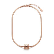 A rose gold snake chain necklace with a cylindrical combination lock charm in the center, displayed on a clean white background.