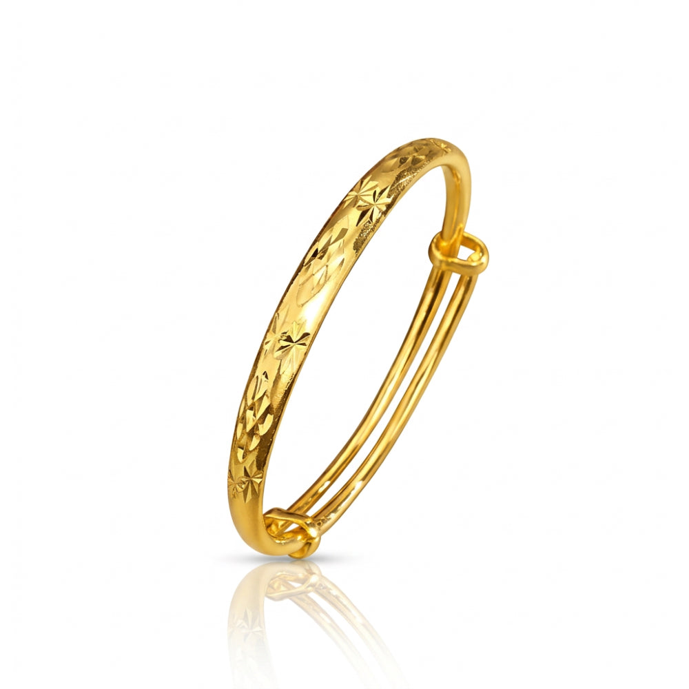 A polished gold hinged bangle bracelet with a textured, star firework-patterned outer surface, shown on a clean white background with a soft reflection below.
