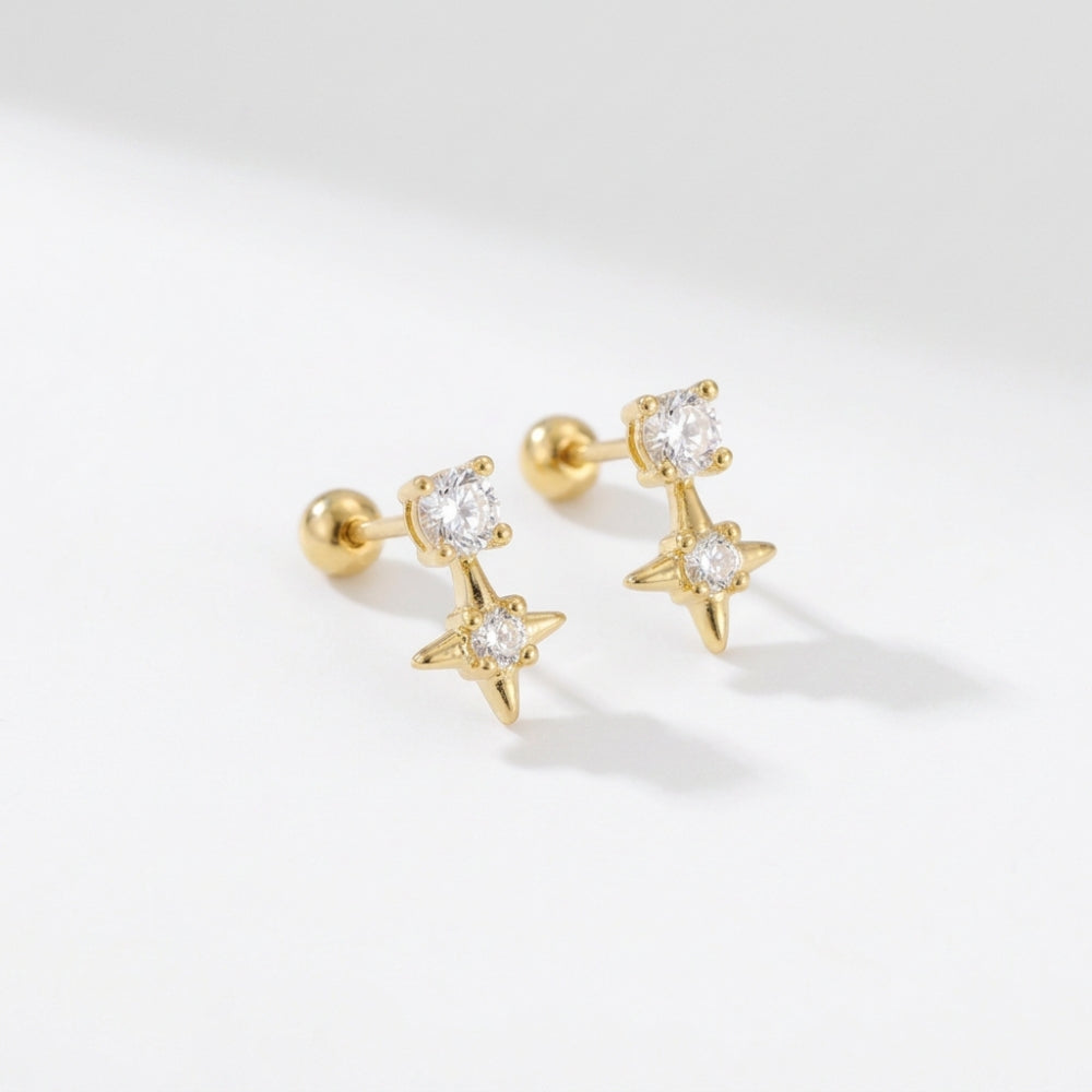 Pair of sparkling star stud earrings in gold with clear CZ crystals on a white background 