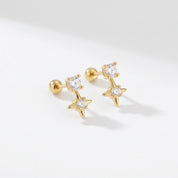 Pair of sparkling star stud earrings in gold with clear CZ crystals on a white background 