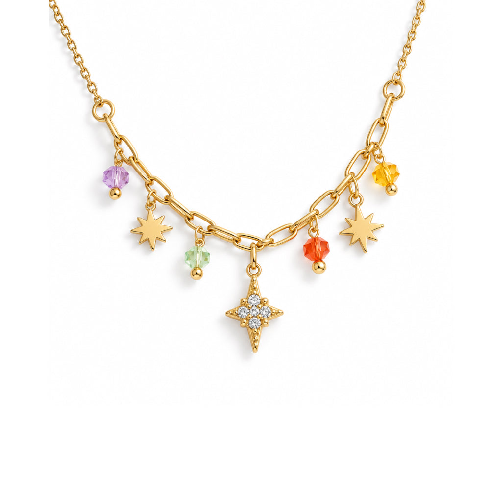 A gold-toned star-themed charm necklace on a white background, featuring a starburst pendant with clear crystals and several dangling star and gem charms in yellow, orange, green, and purple.