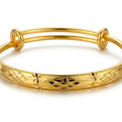 A gold-plated double-strand bangle bracelet with a textured, star-patterned outer band, shown on a clean white background.