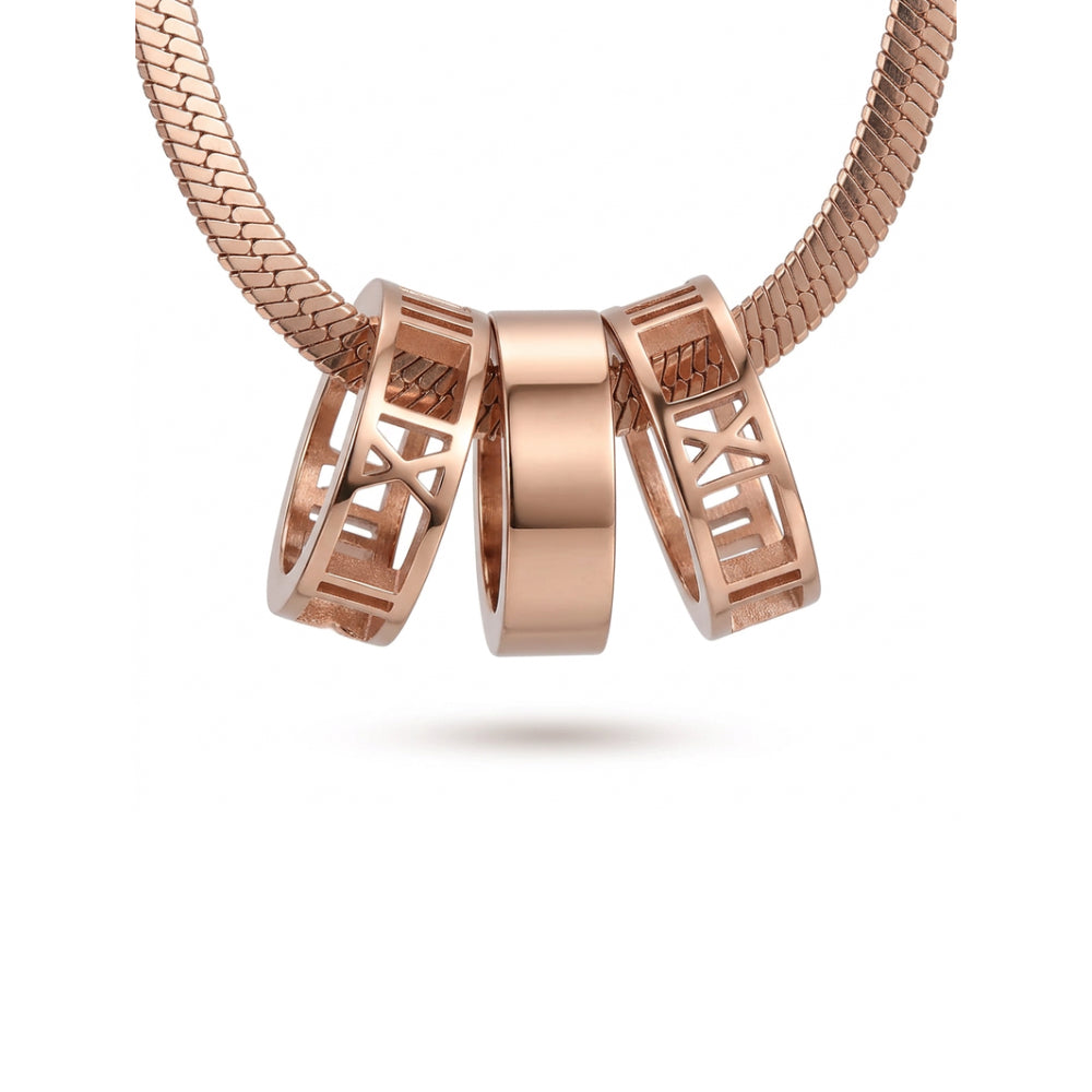 Three rose gold jewelry charms with Roman numerals and openwork details, suspended from a matching snake-style chain against a clean white background.