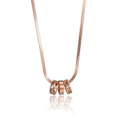 A rose gold necklace with a fine snake chain and a pendant consisting of three interlocking rings
