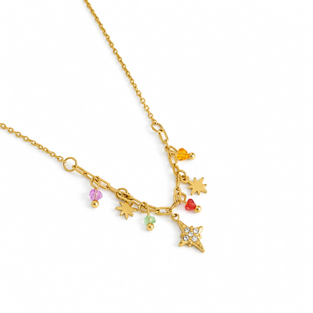 A gold-toned charm necklace featuring a delicate chain with multiple dangling charms, including a star, sun, moon, heart, and small colorful gem accents, displayed on a clean white background.