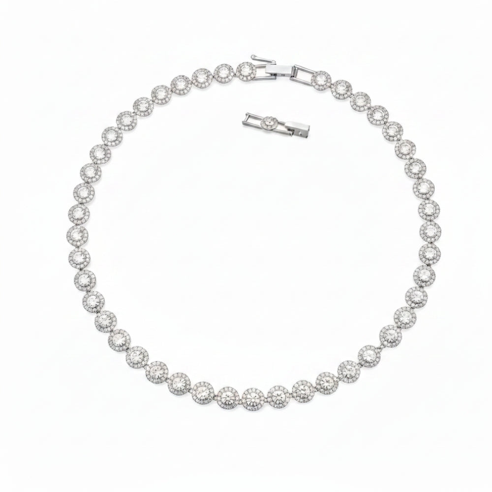 A silver tennis bracelet featuring round pavé-set clear stones, displayed on a clean white background with its clasp and extender visible.