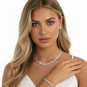 Blonde woman wearing sparkling stud earrings, necklace and bracelet 