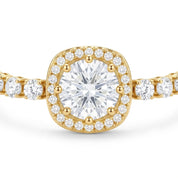 A yellow gold halo ring featuring a cushion-cut center diamond surrounded by a halo of smaller round diamonds, with a diamond-set band extending to the sides, shown on a white background.