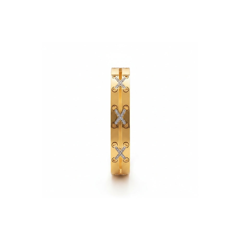 A slim gold bangle bracelet featuring three vertical rows of interlocking 'X' motifs paved with small clear stones, shown on a plain white background.