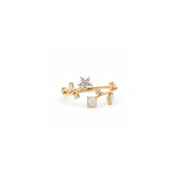 A delicate gold ring featuring a floral branch design with white opal-like round stones and small clear crystal accents, photographed on a seamless white background.