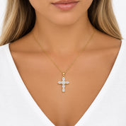 Model wearing a gold cz cross pendant necklace, wearing a white top 