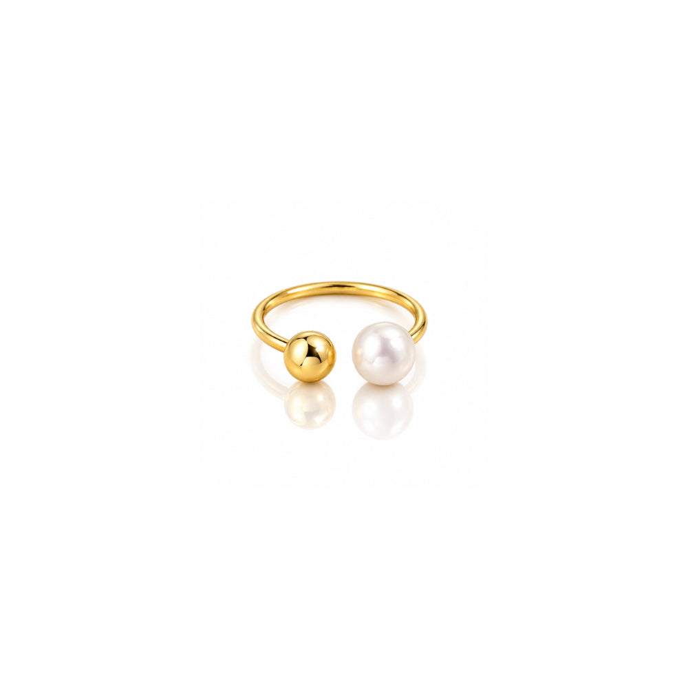 A gold-plated open ring featuring two spherical beads, one polished gold and one white freshwater pearl, displayed on a clean white background with a soft reflection.