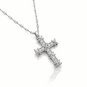 A silver cross pendant necklace paved with small clear stones, featuring a barbed wire design at the ends, shown on a white background with a soft reflection.