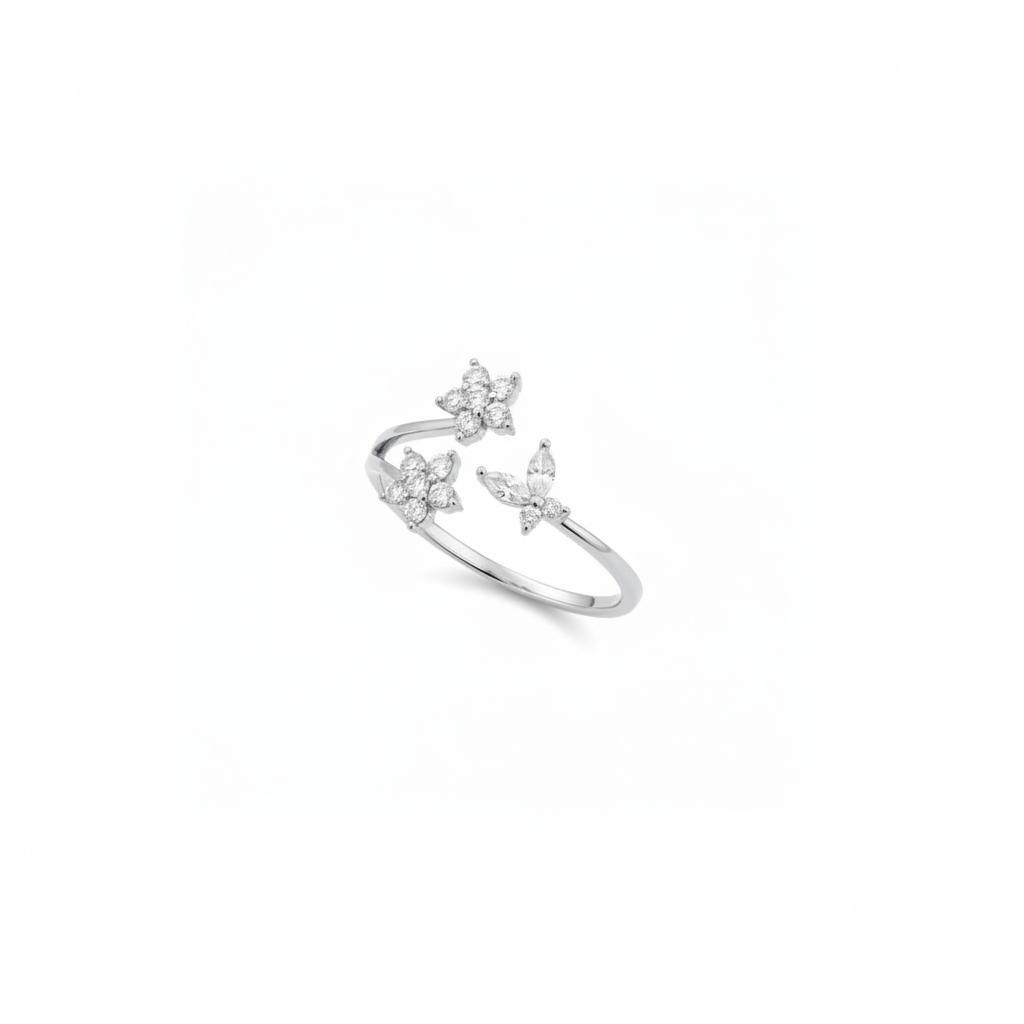A silver open ring ring featuring three butterfly and flower motifs set with small clear stones, photographed on a seamless white background.